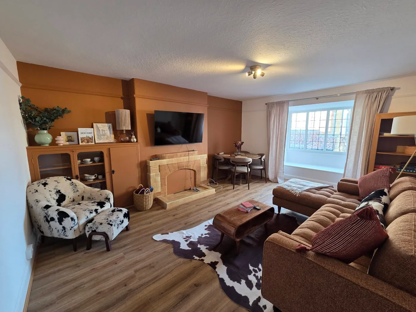 The finished living room, with a warm feature wall and new flooring.