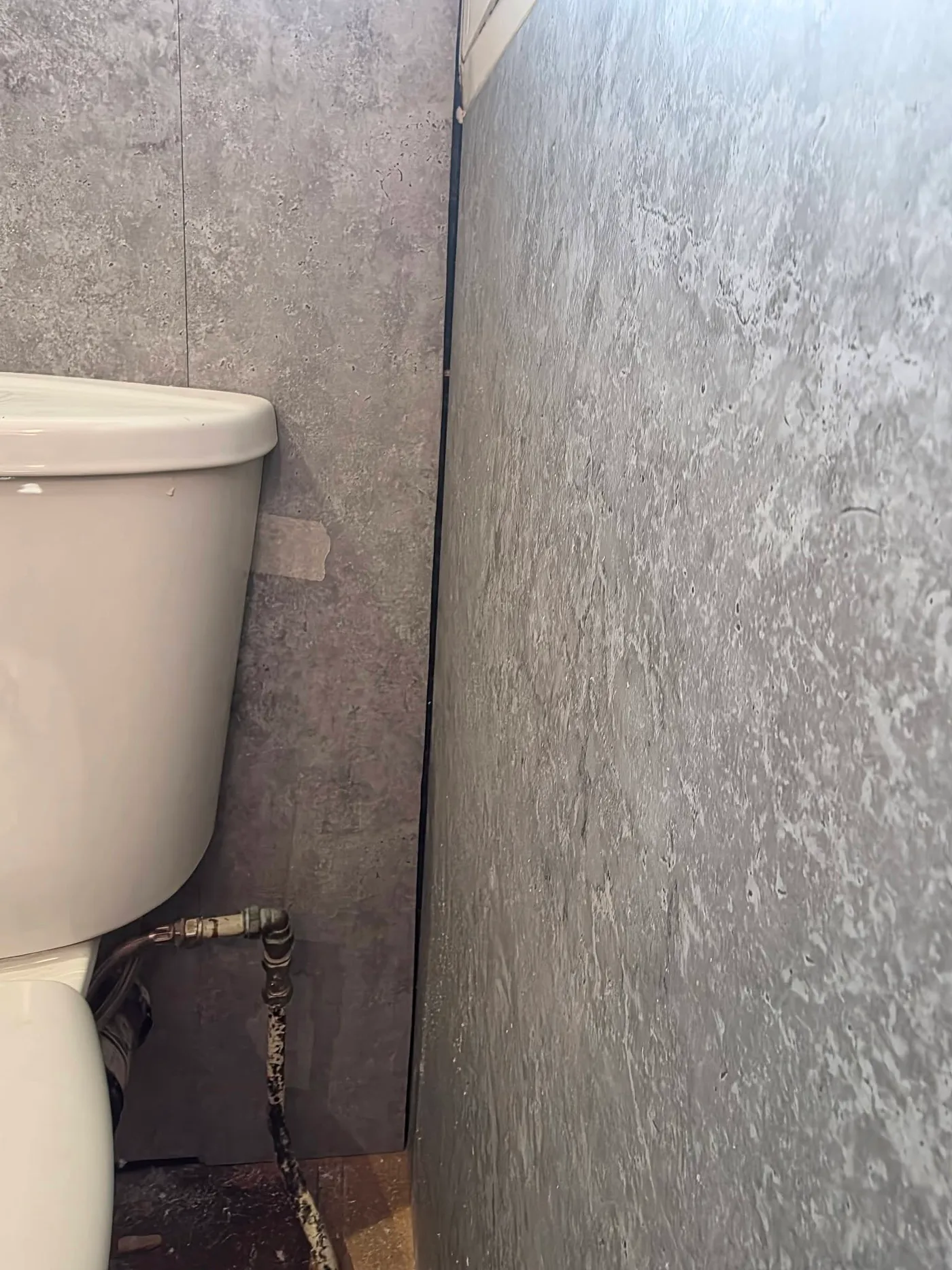 The toilet area and adjacent wall before corrective work.