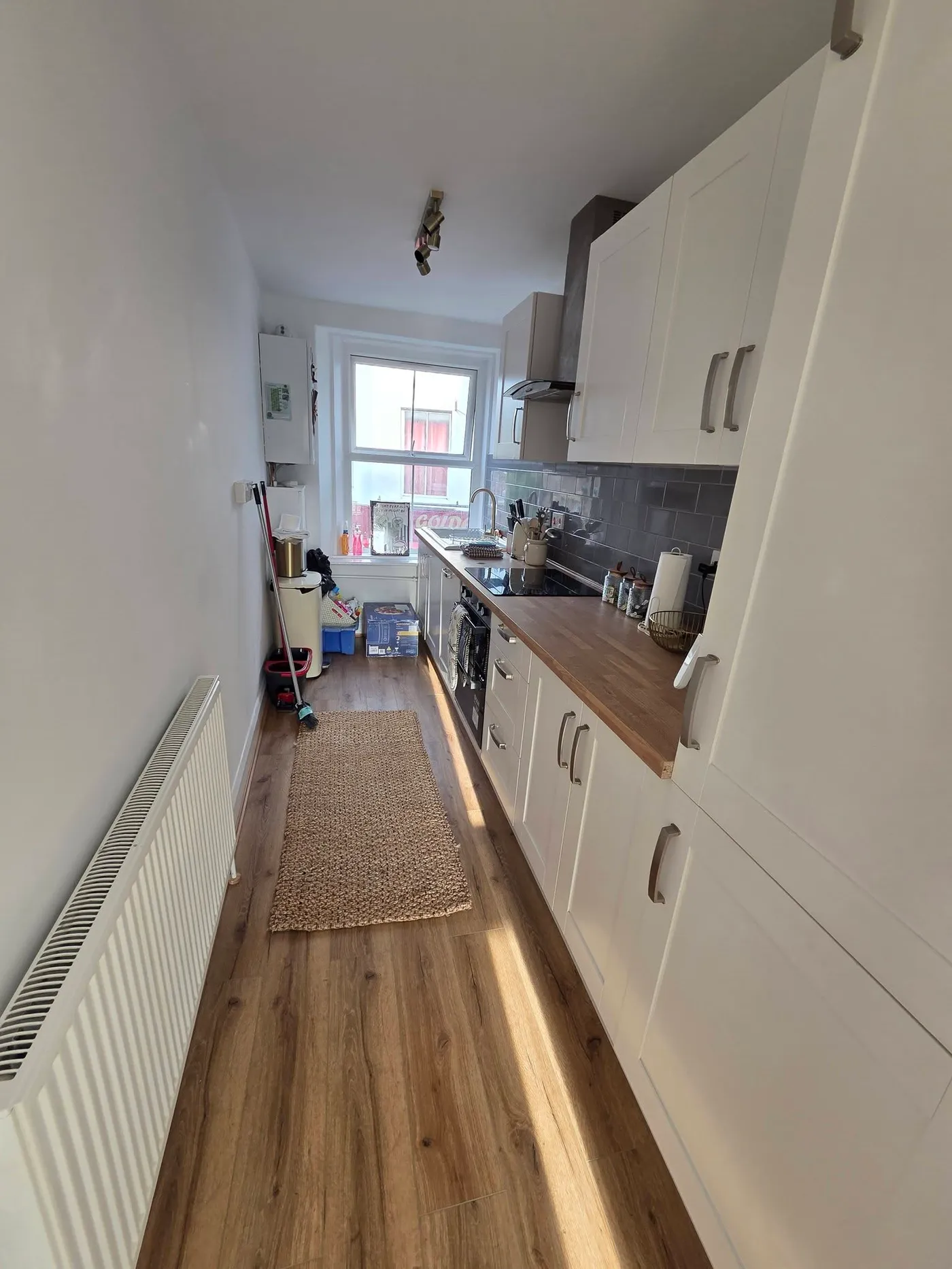 The refreshed kitchen with light cabinet doors and a timber worktop.