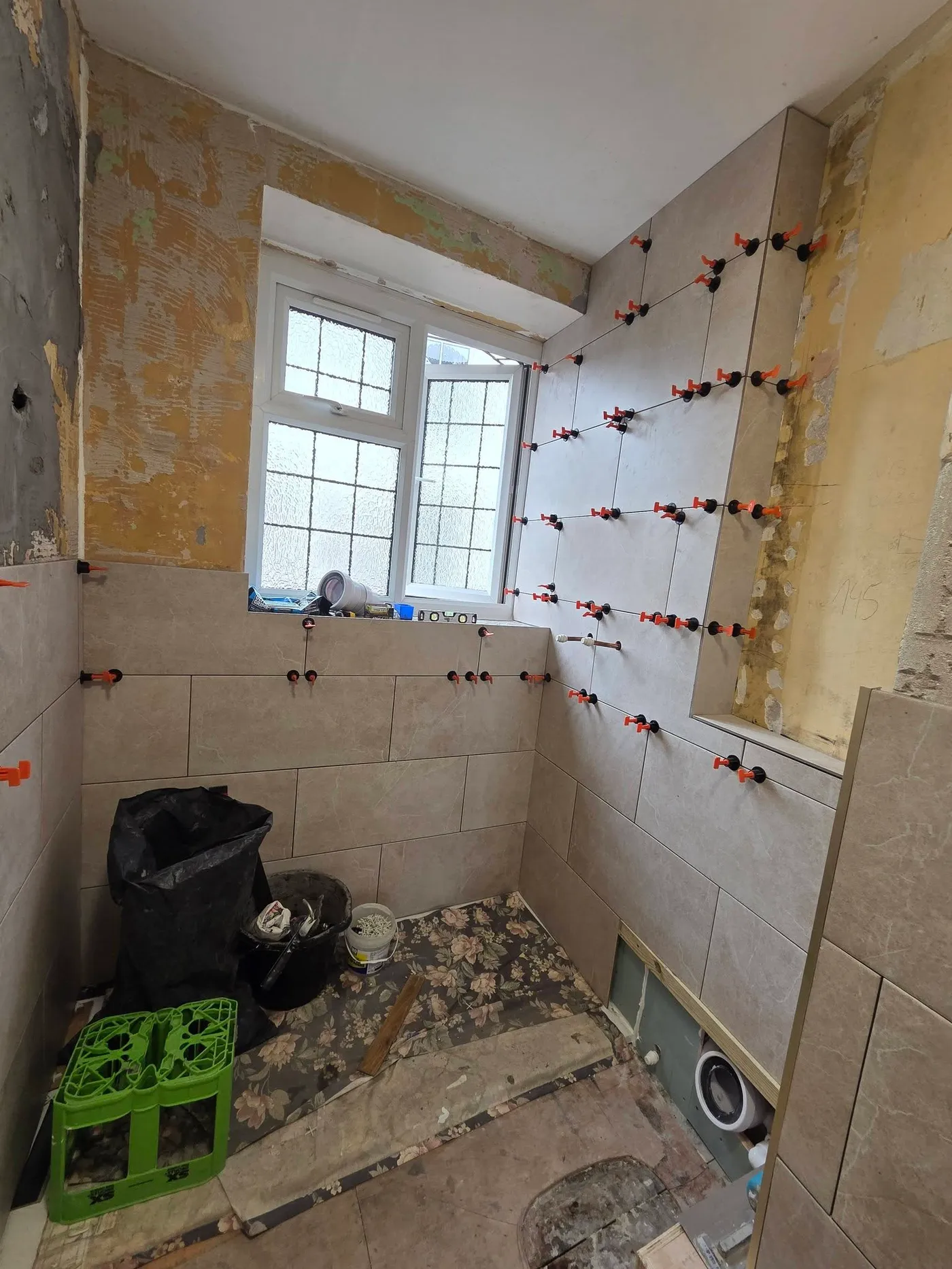 The bathroom stripped back, with wall surfaces and the floor exposed.