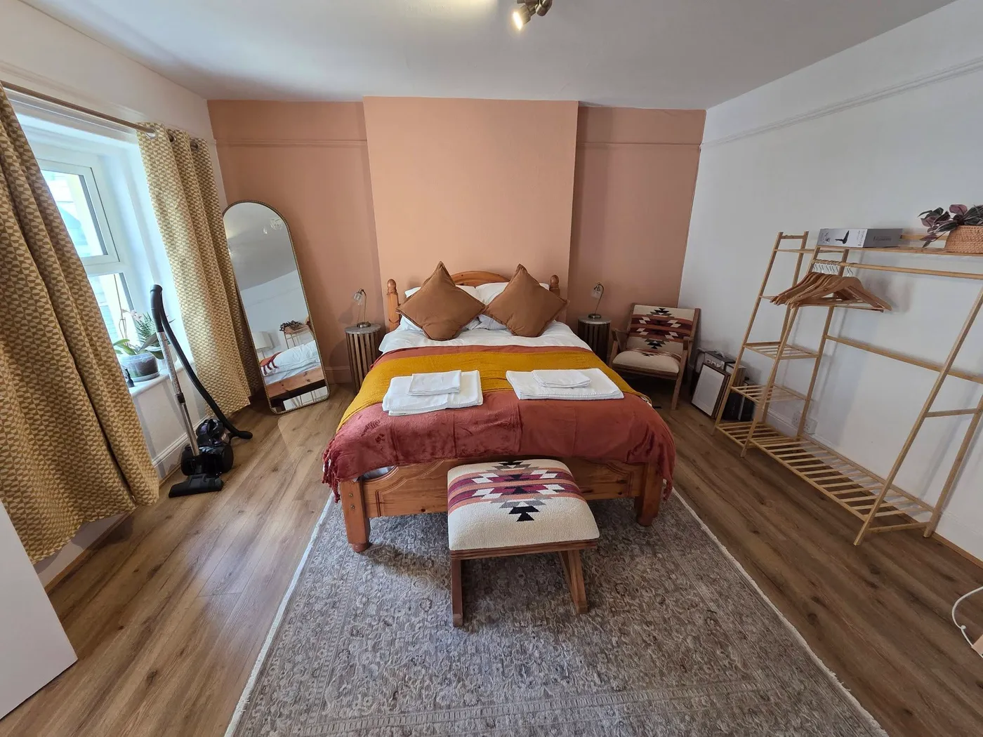 A finished bedroom with a warm accent wall and new flooring.