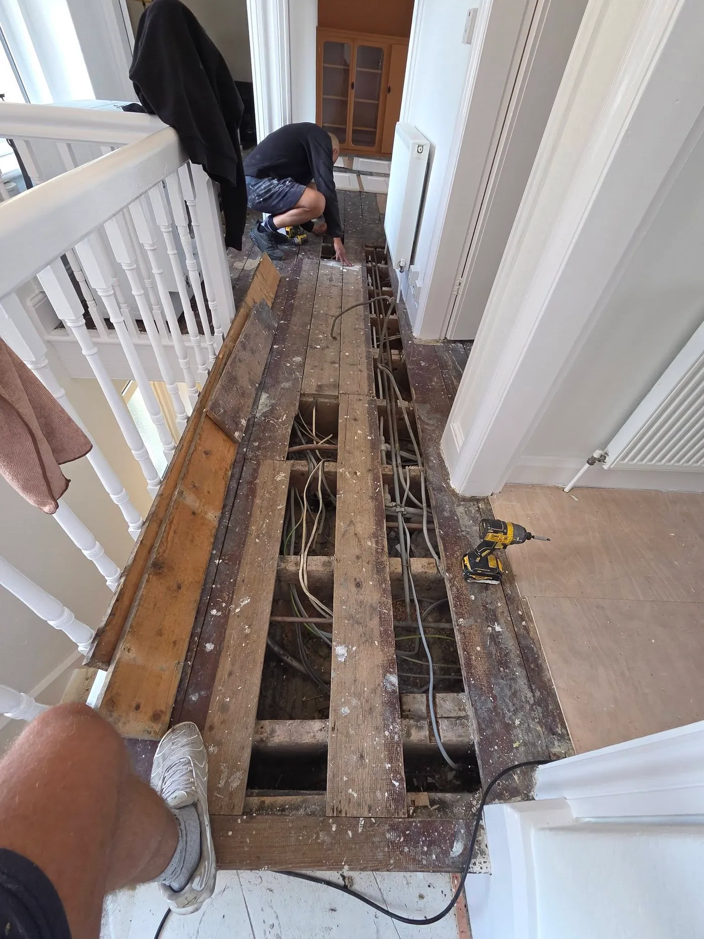 Landing floorboards lifted to expose the space beneath.